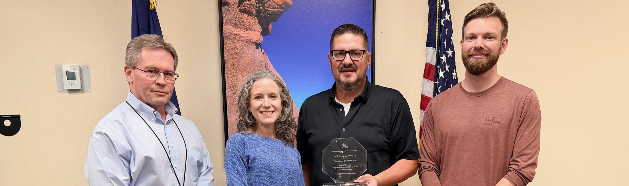 Section 8 Program Manager Kelly Shields, MBOH Executive Director Cheryl Cohen, Operations Manager Joe DeFilippis and Research Economist Ben Gill accepted the award from the National Council of State Housing Agencies. Photo credit: Commerce.